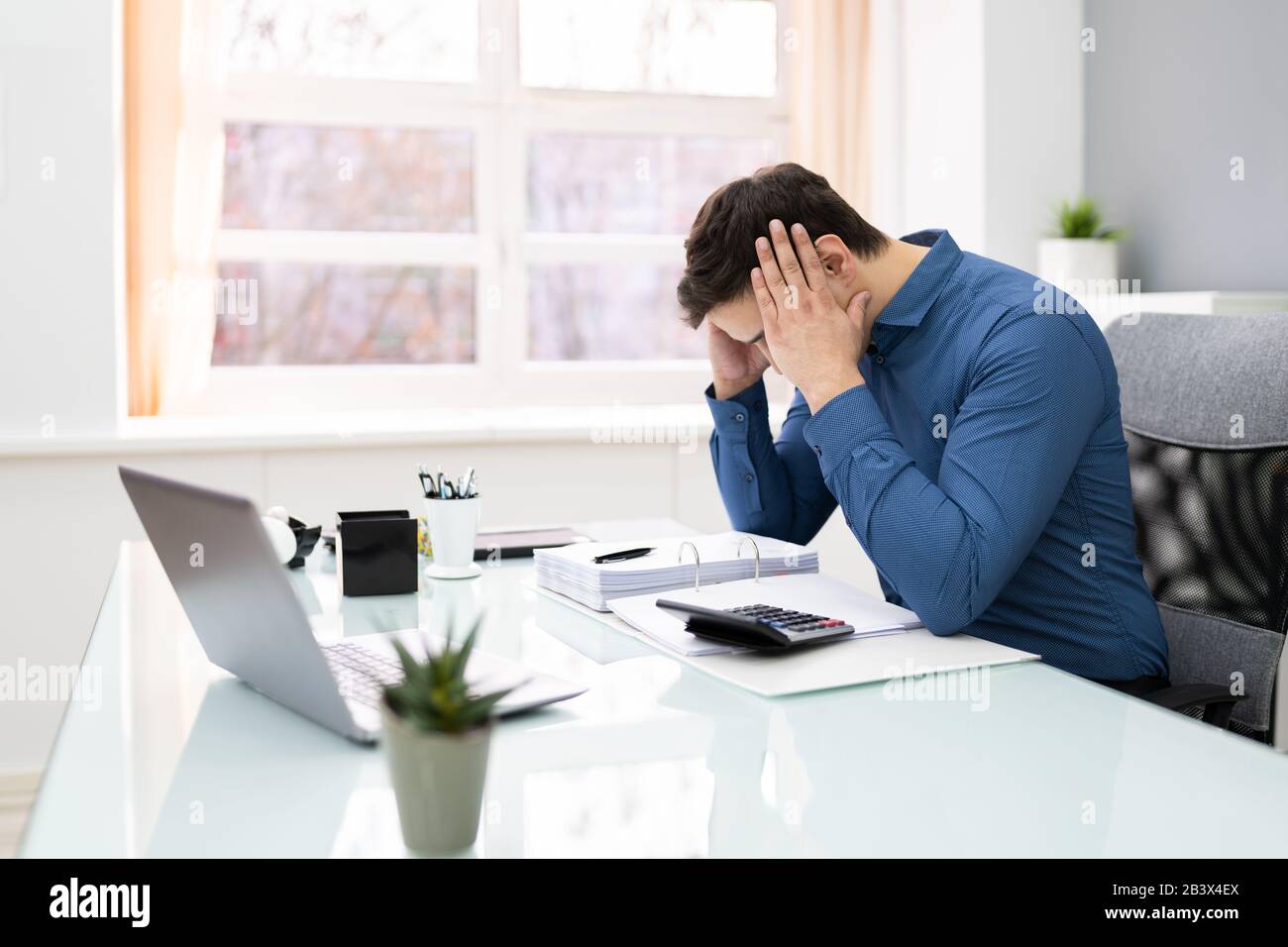 Junge Unternehmer, Die Die Steuer Am Schreibtisch Im Büro Berechnen Stockfoto