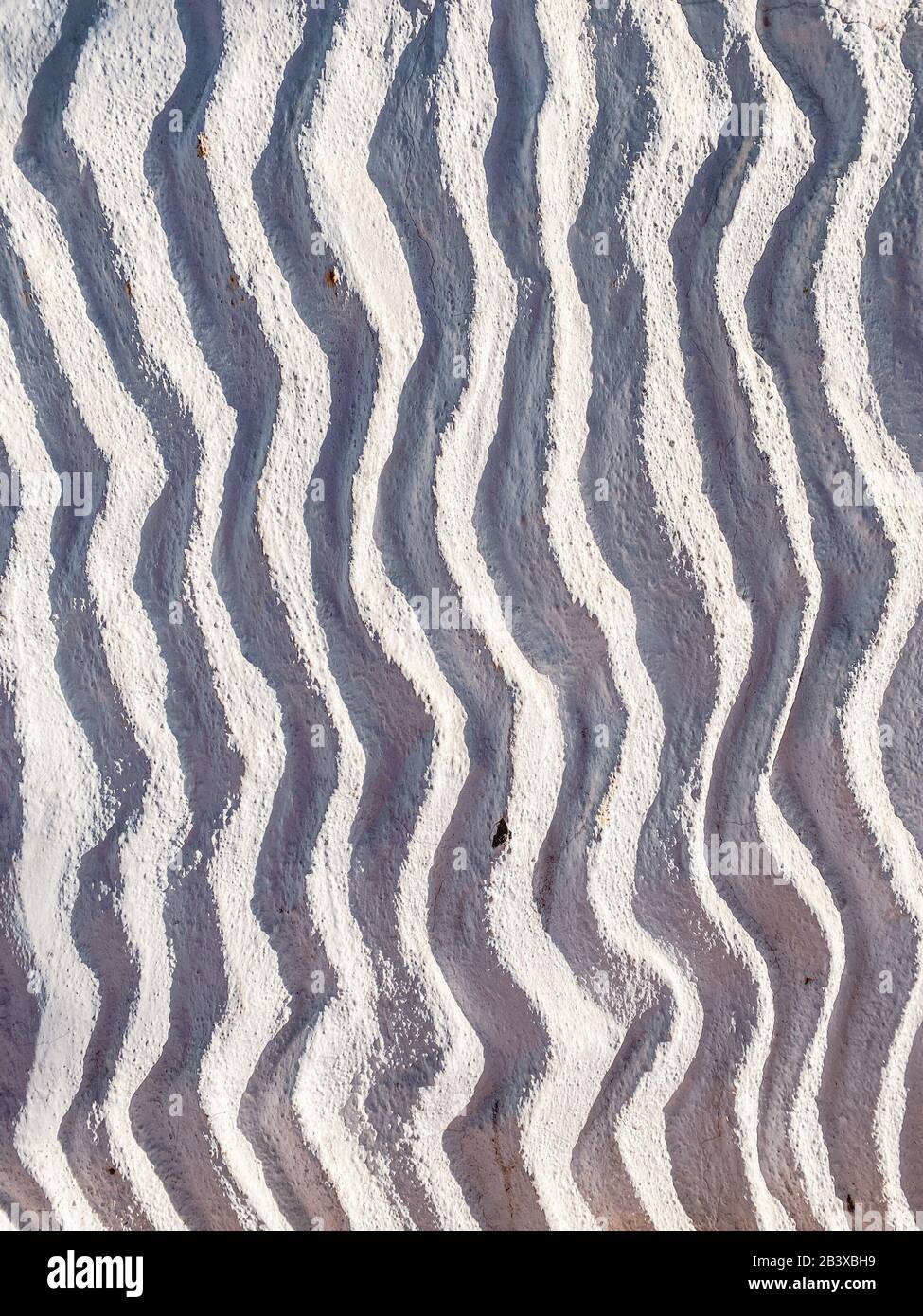Gewellte Struktur der Kucko-Wand im Freien, Nahaufnahme. Bild auf Handy gemacht Stockfoto