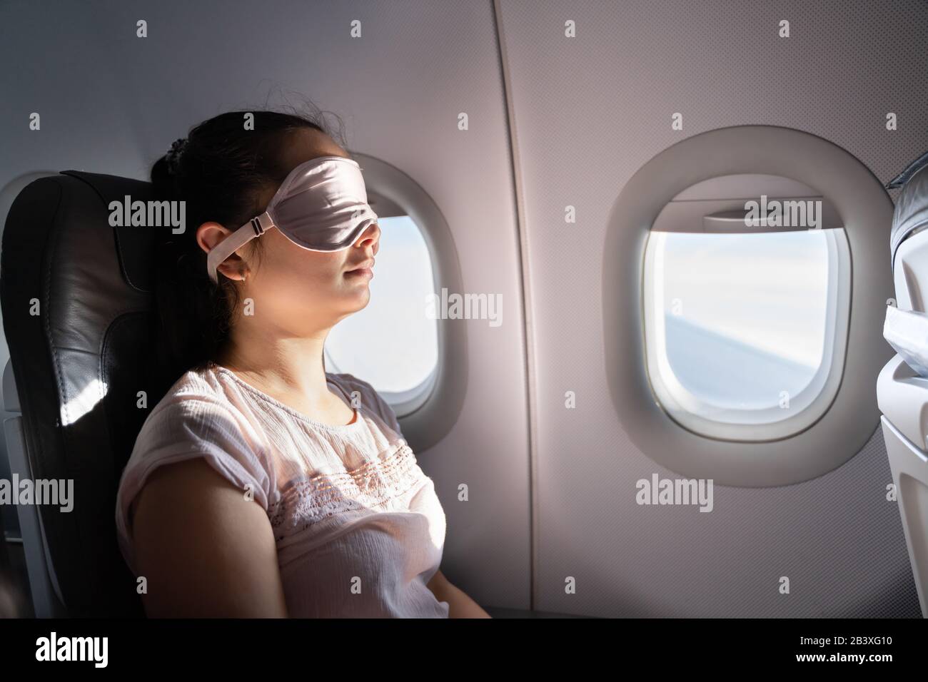 Junge Frau Schläft Mit Schlafmaske Im Flugzeug Stockfoto