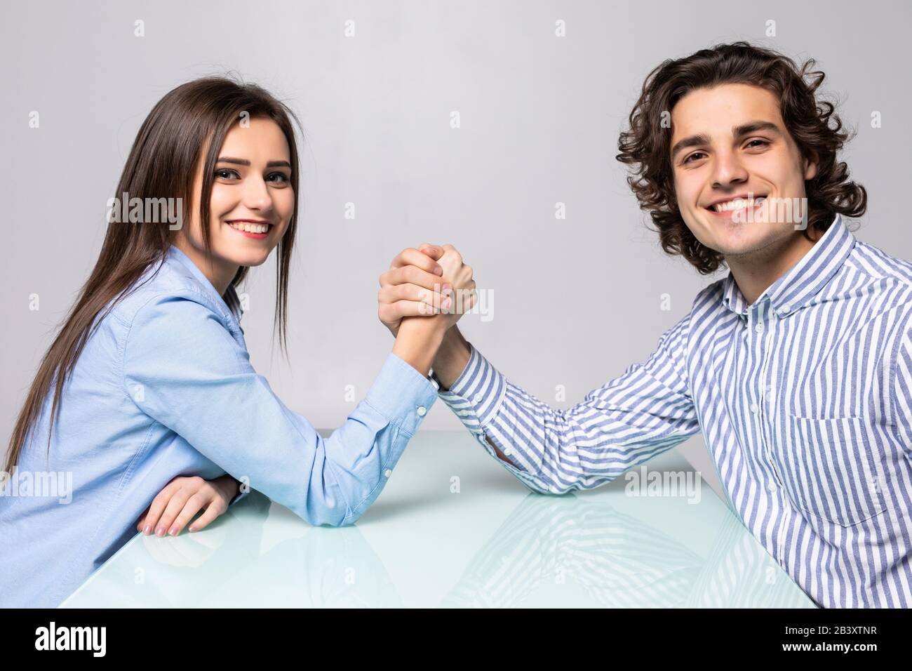 Mann und Frau kämpfen in ihren Armen, Armringen zwischen Mann und Frau. Familienstreit, Showdown, Aufteilung des Eigentums, Scheidung. Stockfoto