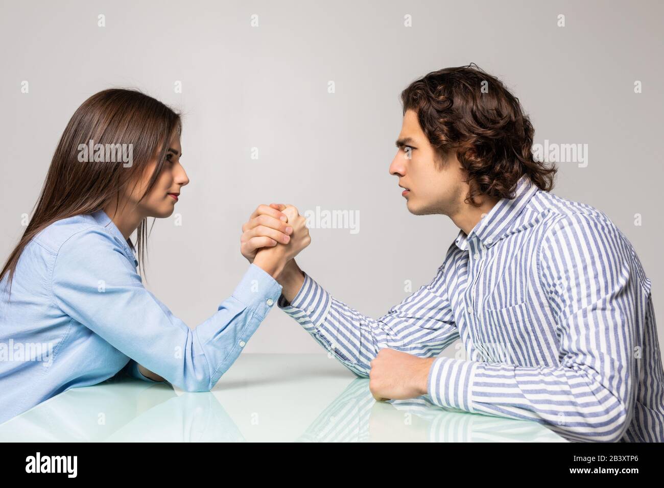 Mann und Frau kämpfen in ihren Armen, Armringen zwischen Mann und Frau. Familienstreit, Showdown, Aufteilung des Eigentums, Scheidung. Stockfoto