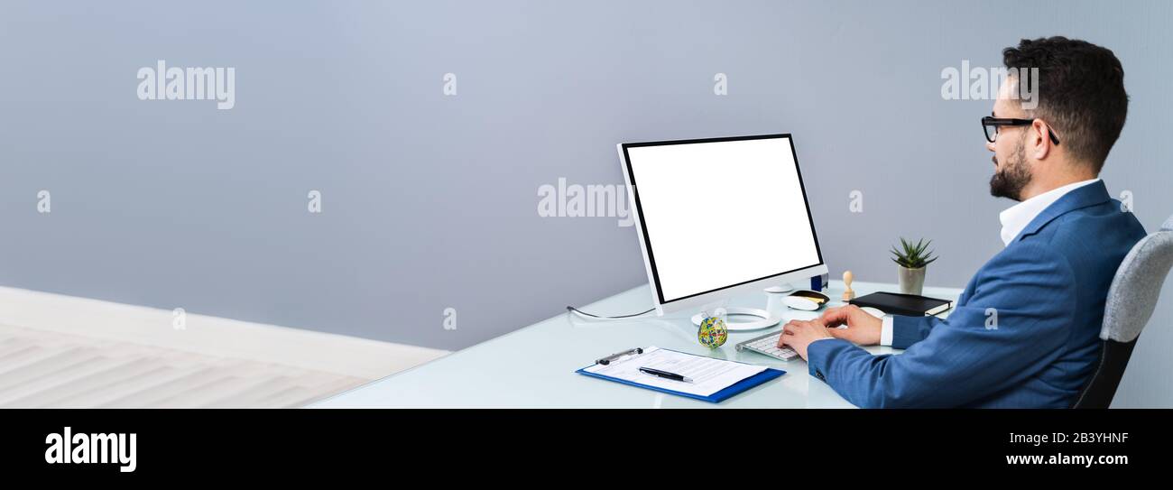 Nahaufnahme Eines Geschäftsmannes, Der Einen Computer Mit Leerem Bildschirm Am Arbeitsplatz verwendet Stockfoto