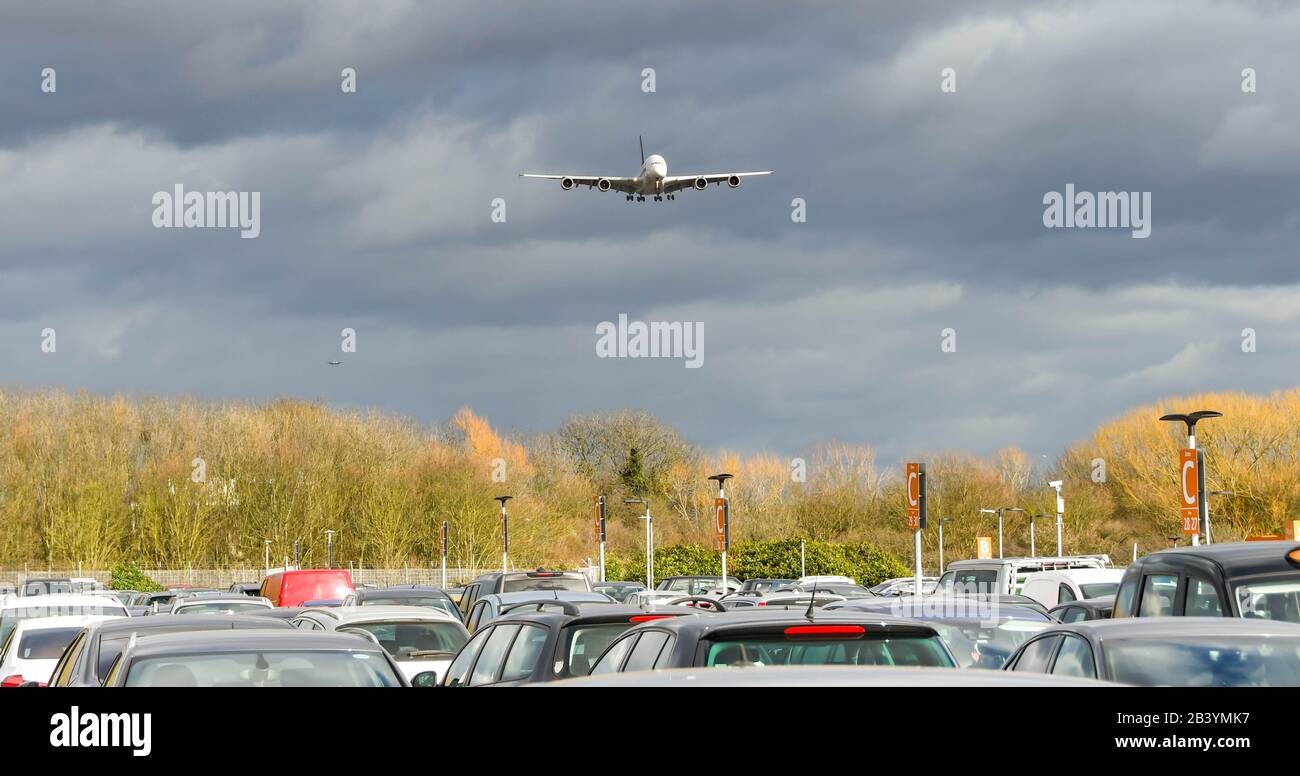 FLUGHAFEN LONDON-HEATHROW - MÄRZ 2019: Airbus A380 kommt über Autos in einem der Langzeitparkplätze am Flughafen London-Heathrow an Land. Stockfoto
