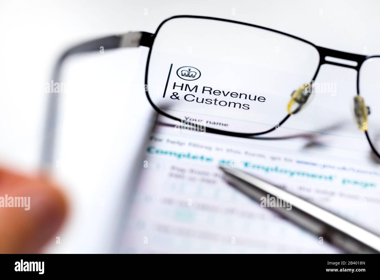 UK Tax Papers und Formulare von HM Revenue Customs unter einem Glas Stockfoto