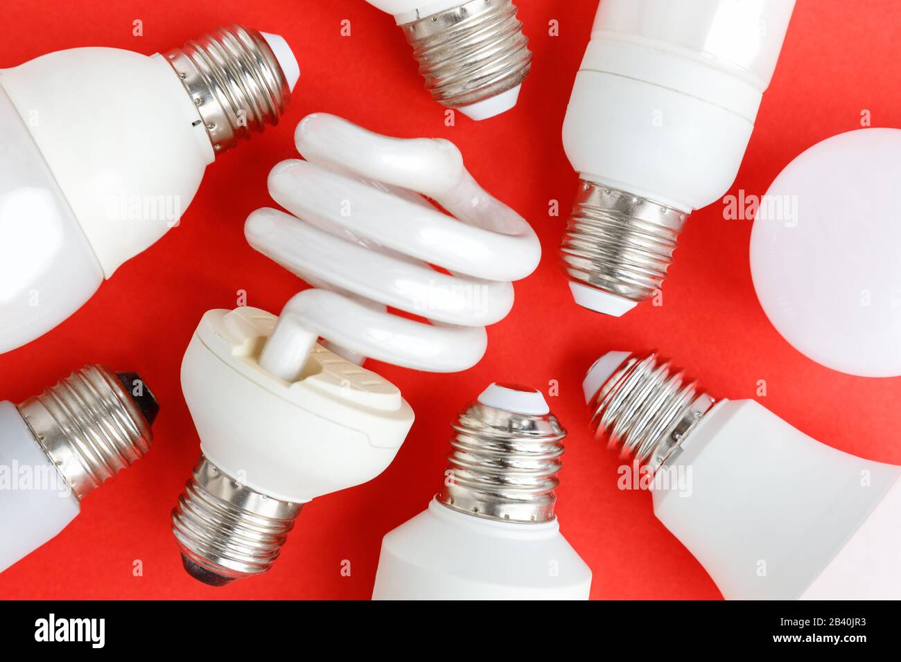 Verbrauchte Halogen-, cfi-Leuchtstoff-, LED-, Lumen- und Energiesparbirnen, Röhre, roter Hintergrund. Quecksilberhaltige Lampen - extrem haza Stockfoto