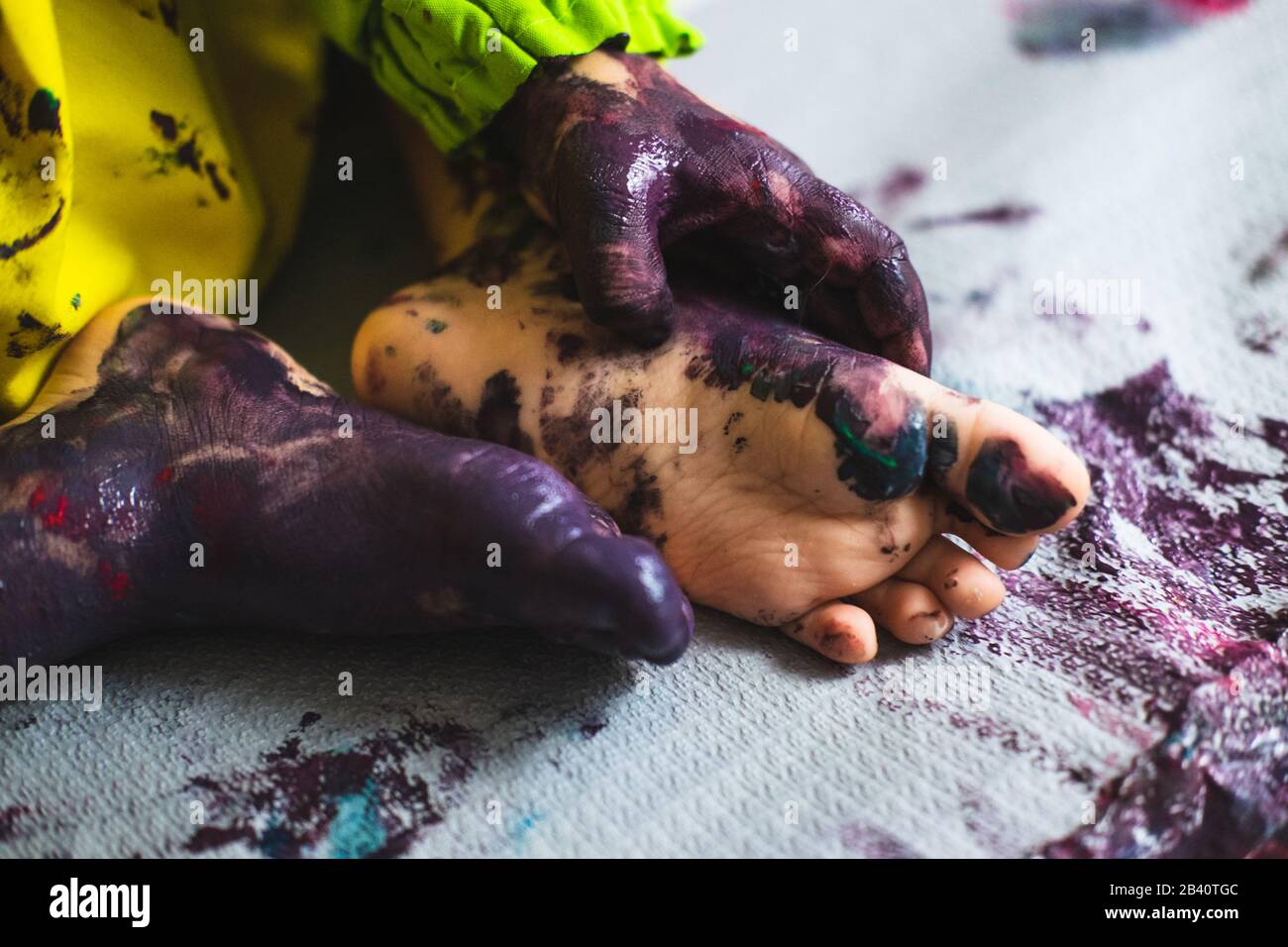 Kleine Kinder Hände und Füße mit mehreren Farben bedeckt Stockfoto