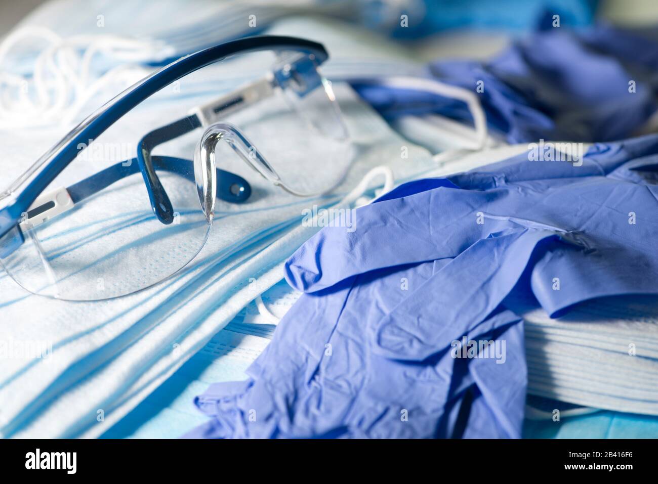 Persönliche Schutzausrüstung, eine Schutzbrille, blaue Masken und blaue Nitrilhandschuhe zur Verhinderung der Infektionsausbreitung. Stockfoto