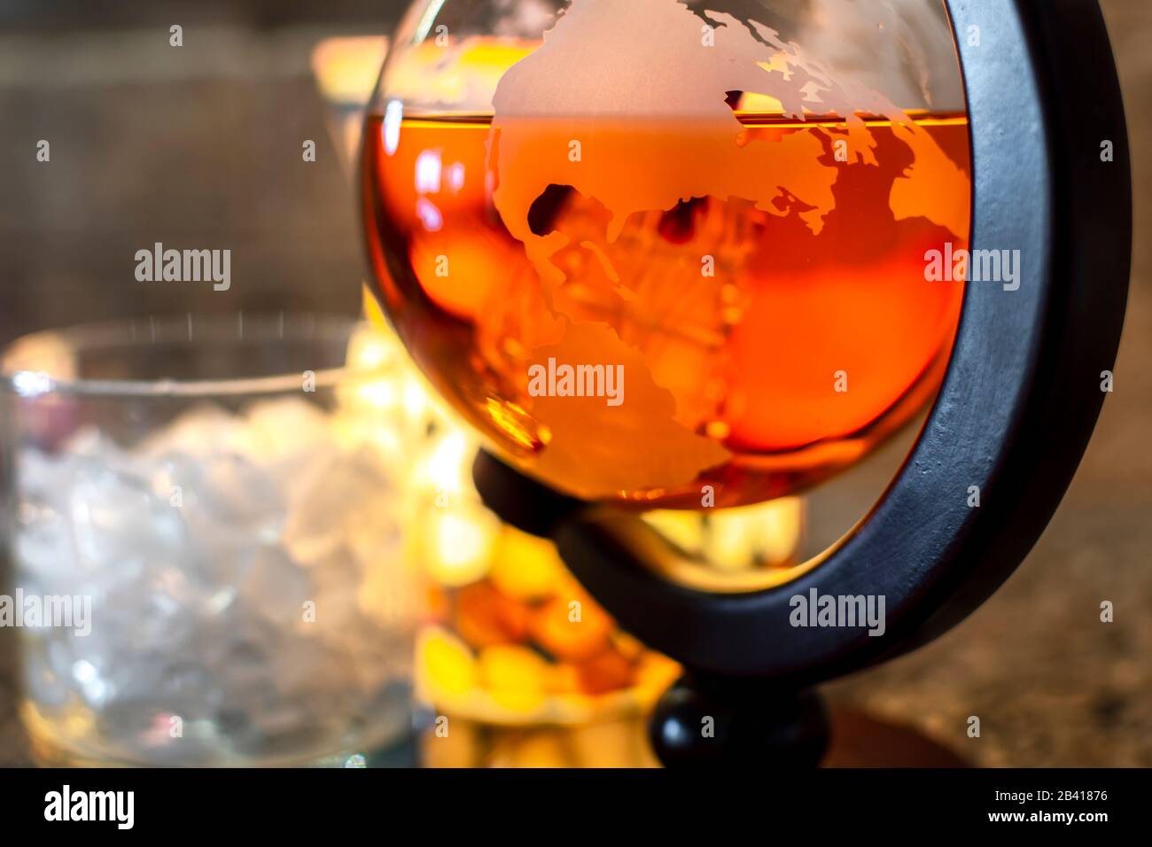 Ein Glasklobus, der Alkoholgenuss aufnehmen soll, ist mit schottischem Whiskey neben einem Glas Eis gefüllt. Stockfoto