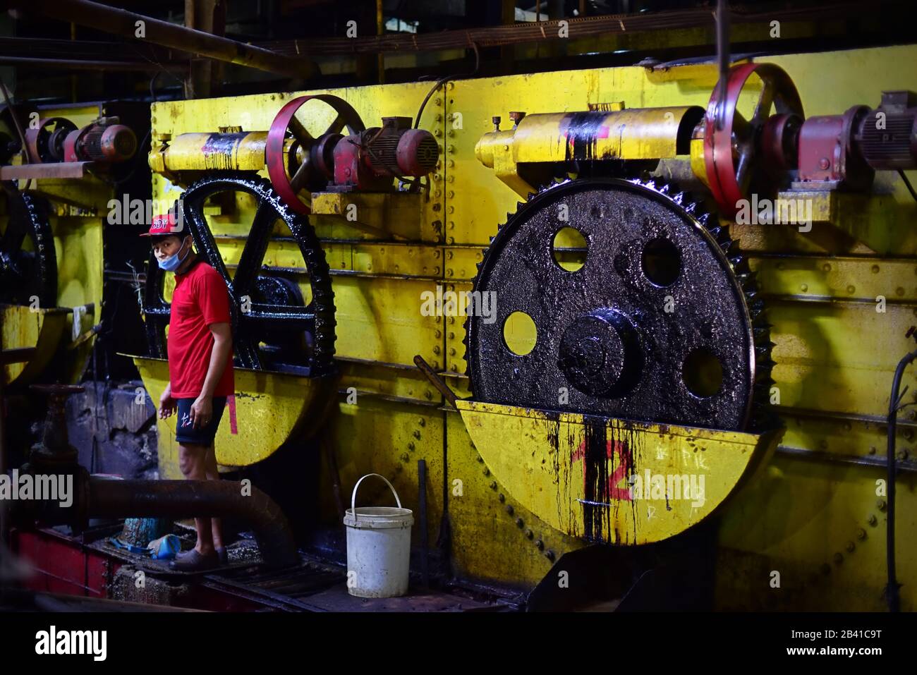 Ein Fabrikarbeiter fotografierte während Wartungsarbeiten vor den Produktionsmaschinen der Zuckerfabrik. © Reynold Sumayku Stockfoto