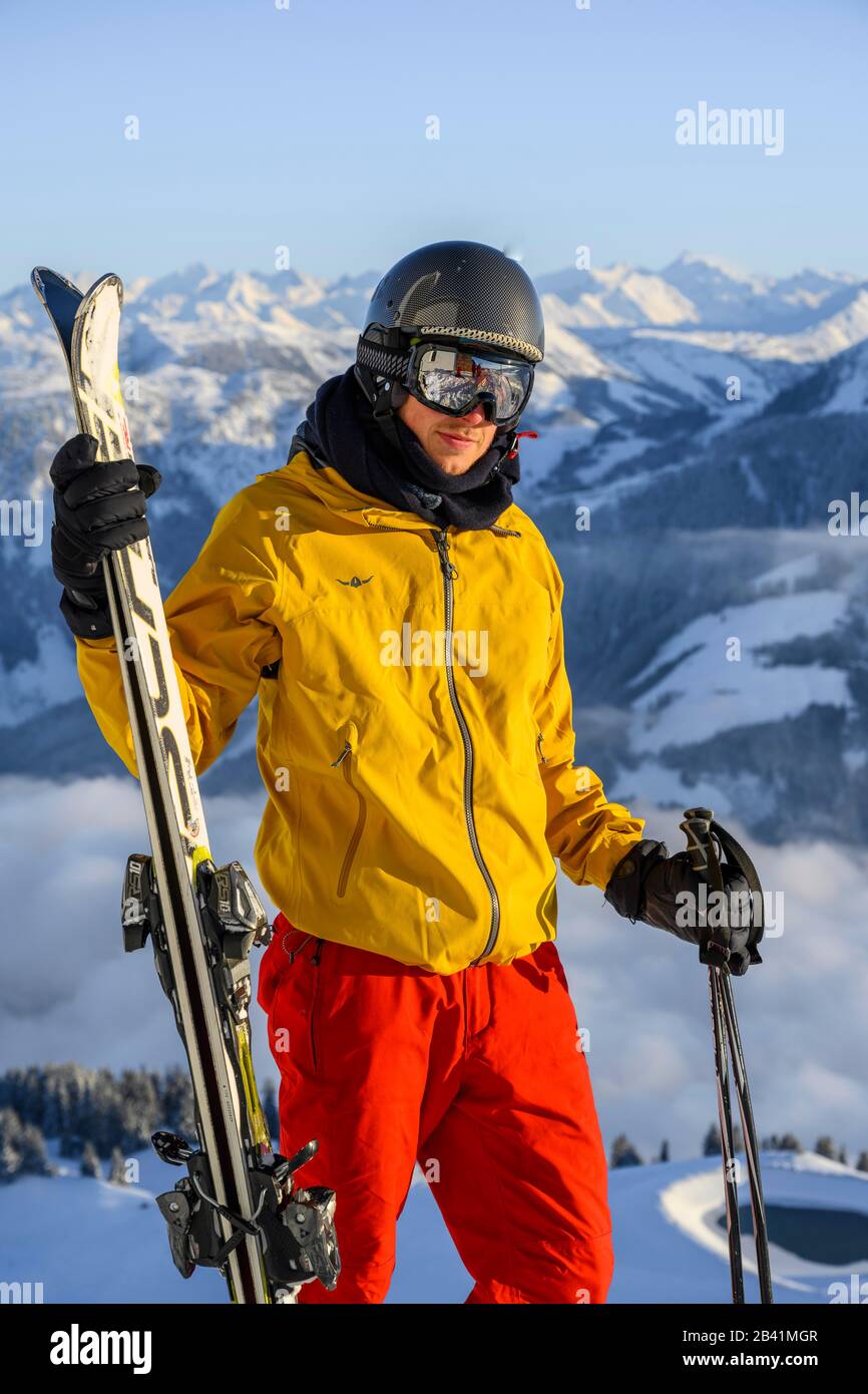 Skifahrer vor dem Bergpanorama, hält Ski, schaut in die Kamera, Gipfel hohe Salve, SkiWelt Wilder Kaiser Brixenthal, Hochbrixen, Tyrol, Österreich Stockfoto