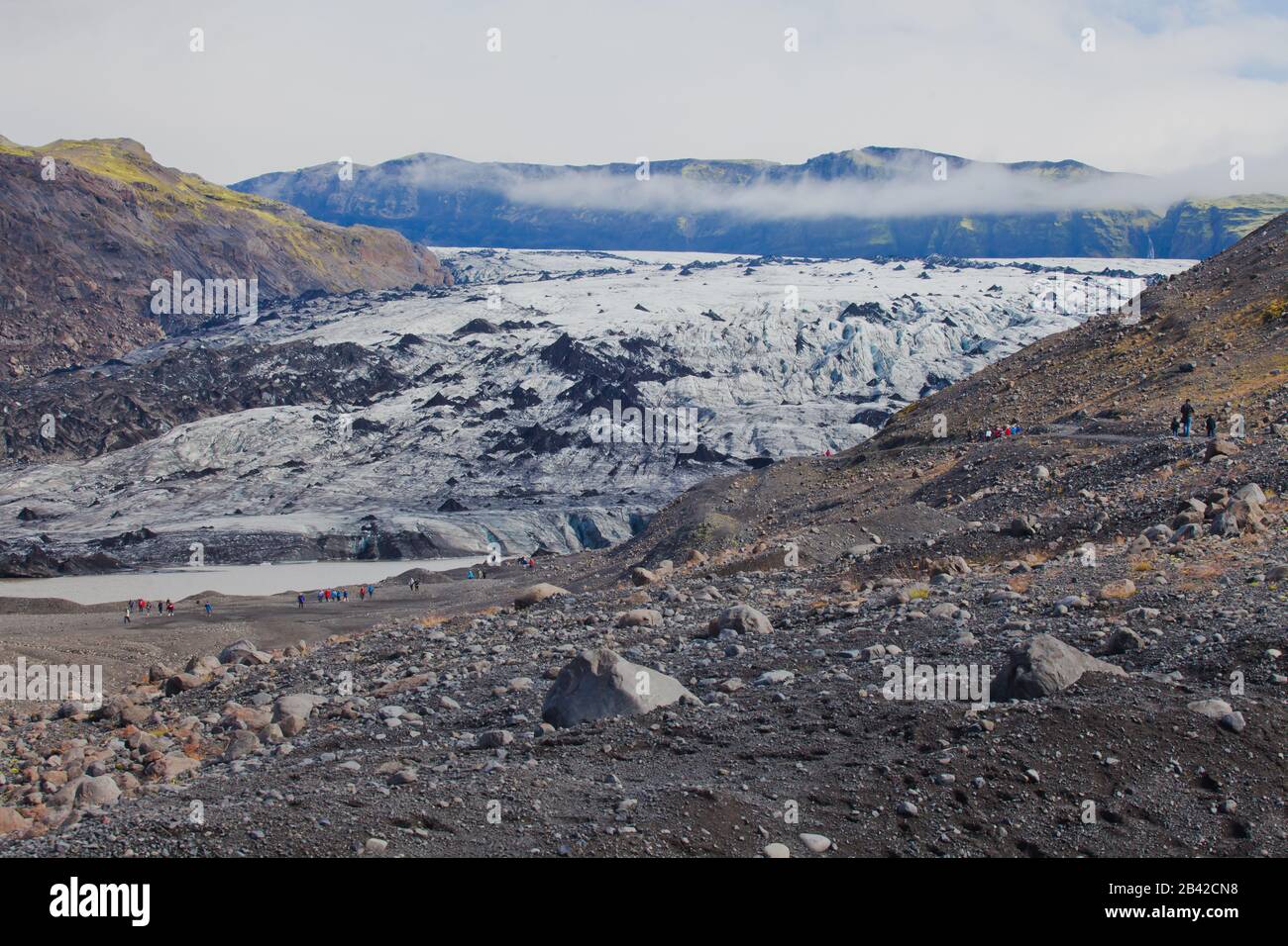 Island-Gletscher mit einer Gruppe von Wanderern, die Touristen wandern, um den berühmten Gletscher in Island zu erkunden Stockfoto