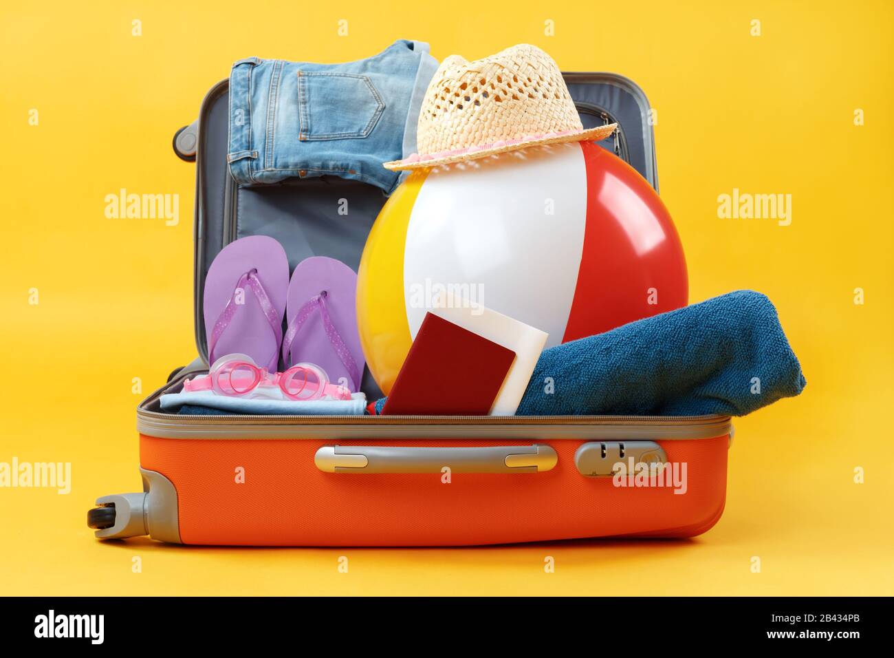 Öffnen Sie den ganzen Koffer mit Gegenständen zur Entspannung auf gelbem Hintergrund. Stockfoto