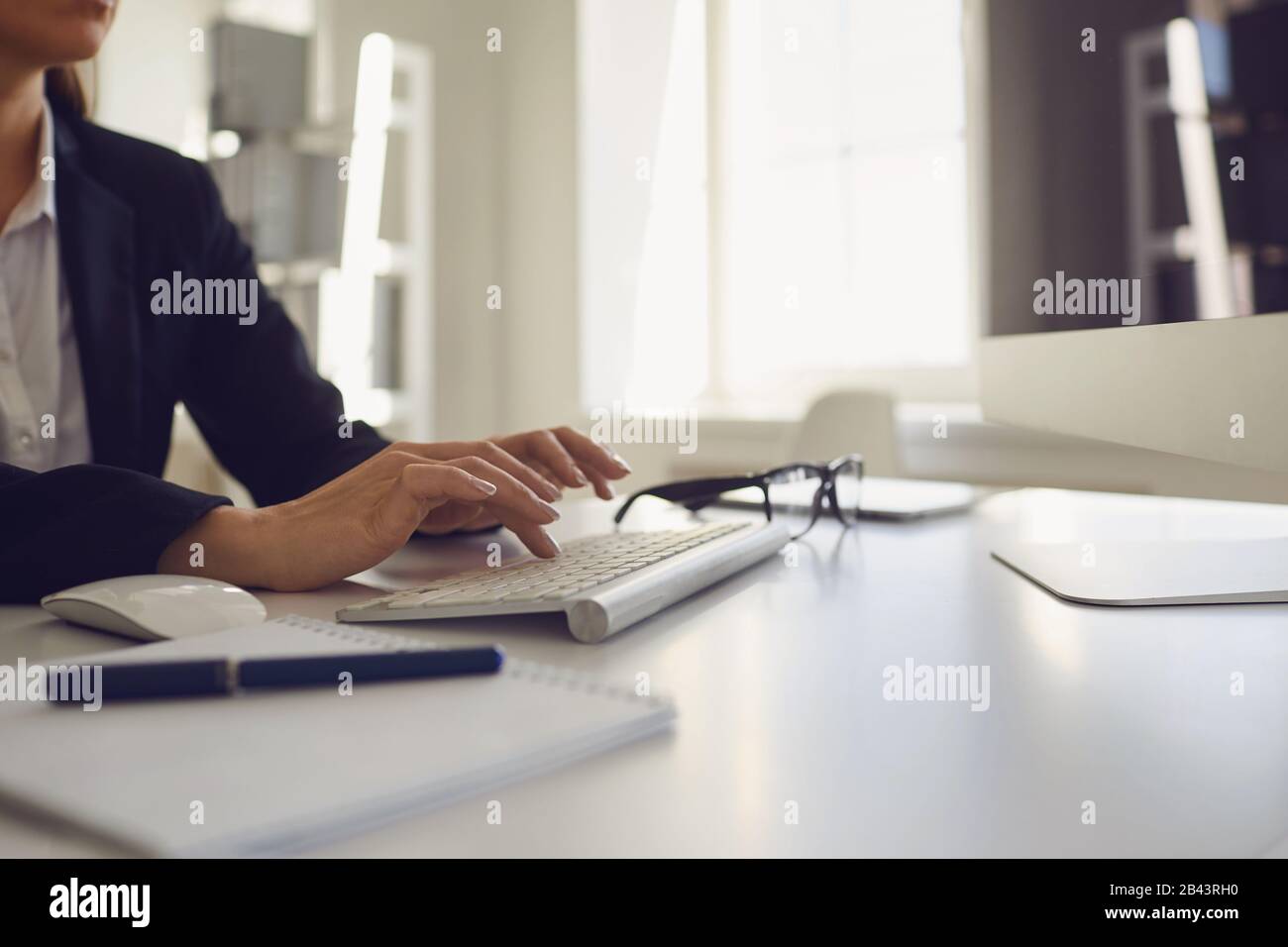 Beschäftigt gesichtsloser Mitarbeiter tippt am Arbeitsplatz mit dem Computer im Büro. Stockfoto