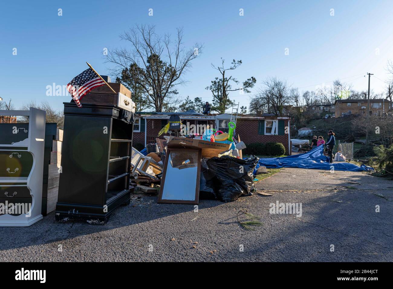 Nashville, Tennessee, USA. März 2020. Wie viele ihrer Nachbarn in East Nashville sitzen auch die beschädigten Gegenstände der Familie Beard auf der Straße und warten auf die Entfernung, während die Arbeiter sich darauf vorbereiten, das roofless Haus zu beflecken, während die Gemeinde mit dem Wiederaufbau nach dem tödlichen Tornado vom 3. März 2020 beginnt. Kredit: Lisbeth Norton/ZUMA Wire/Alamy Live News Stockfoto