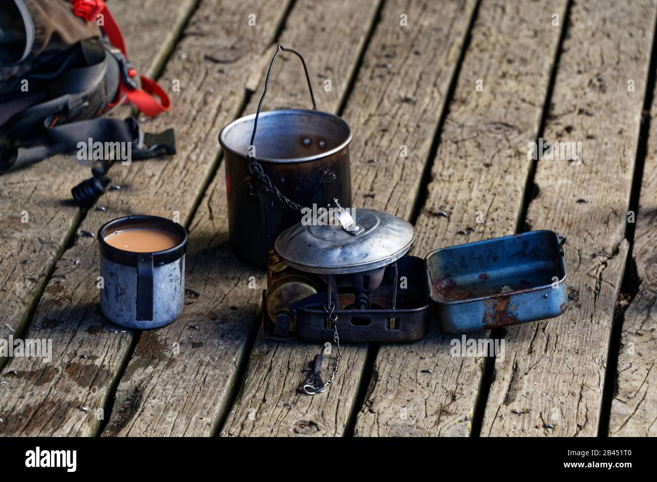 Ein Zinn Becher milchigen Tees sitzt mit einem billy und anderen Töpfen Stockfoto