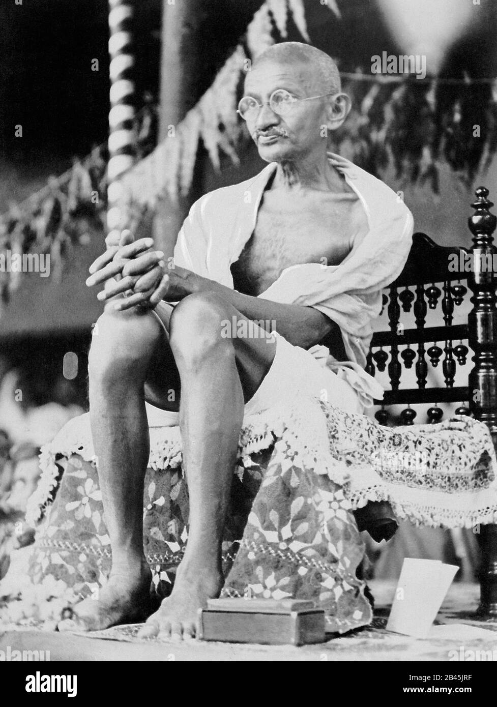 Mahatma Gandhi sitzt auf einem handgefertigten Stuhl, Indien, 1930, altes Vintage 1900er Bild Stockfoto