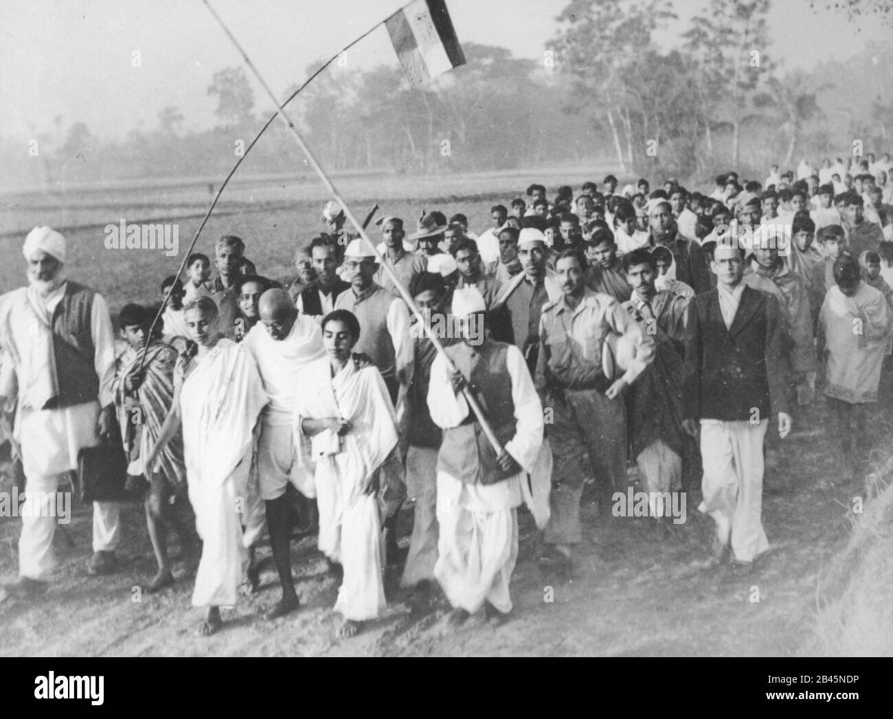 Mahatma Gandhi mit Dorfbewohnern auf friedensmarsch nach Ausschreitungen durch die Felder von Noakhali, Westbengalen, Indien, Asien, Dezember 1946 altes Jahrgangsbild aus dem 19. Jahrhundert Stockfoto