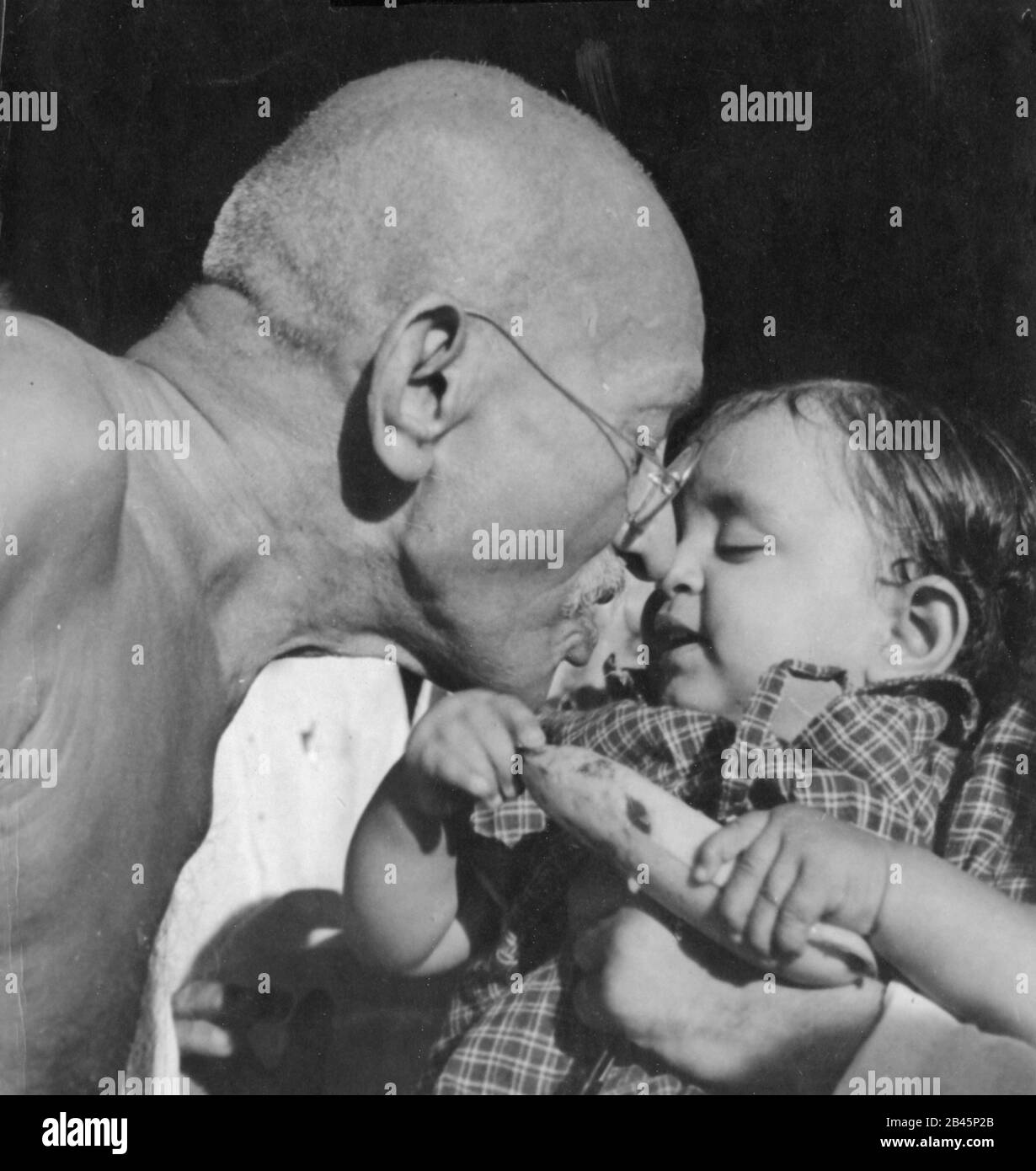 Mahatma Gandhi kuschelt Baby Nandini Nichte des Gandhi-Sekretärs Pyarelal Nayer, Sewagram Ashram, Wardha, Maharashtra, Indien, 1944 Stockfoto