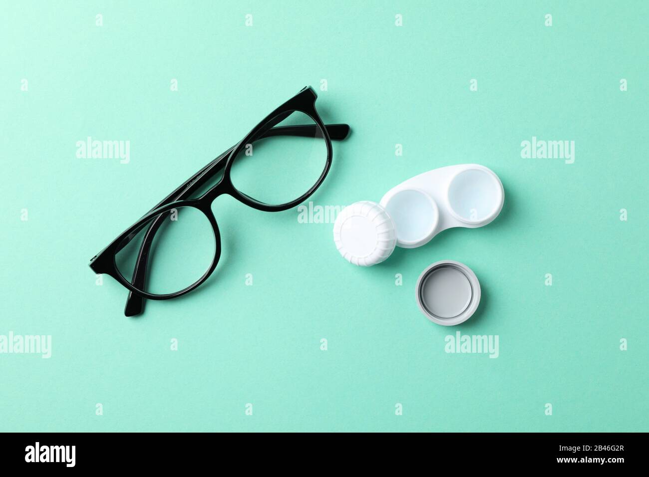 Brille und Kontaktlinsen auf Minzhintergrund, Draufsicht Stockfoto