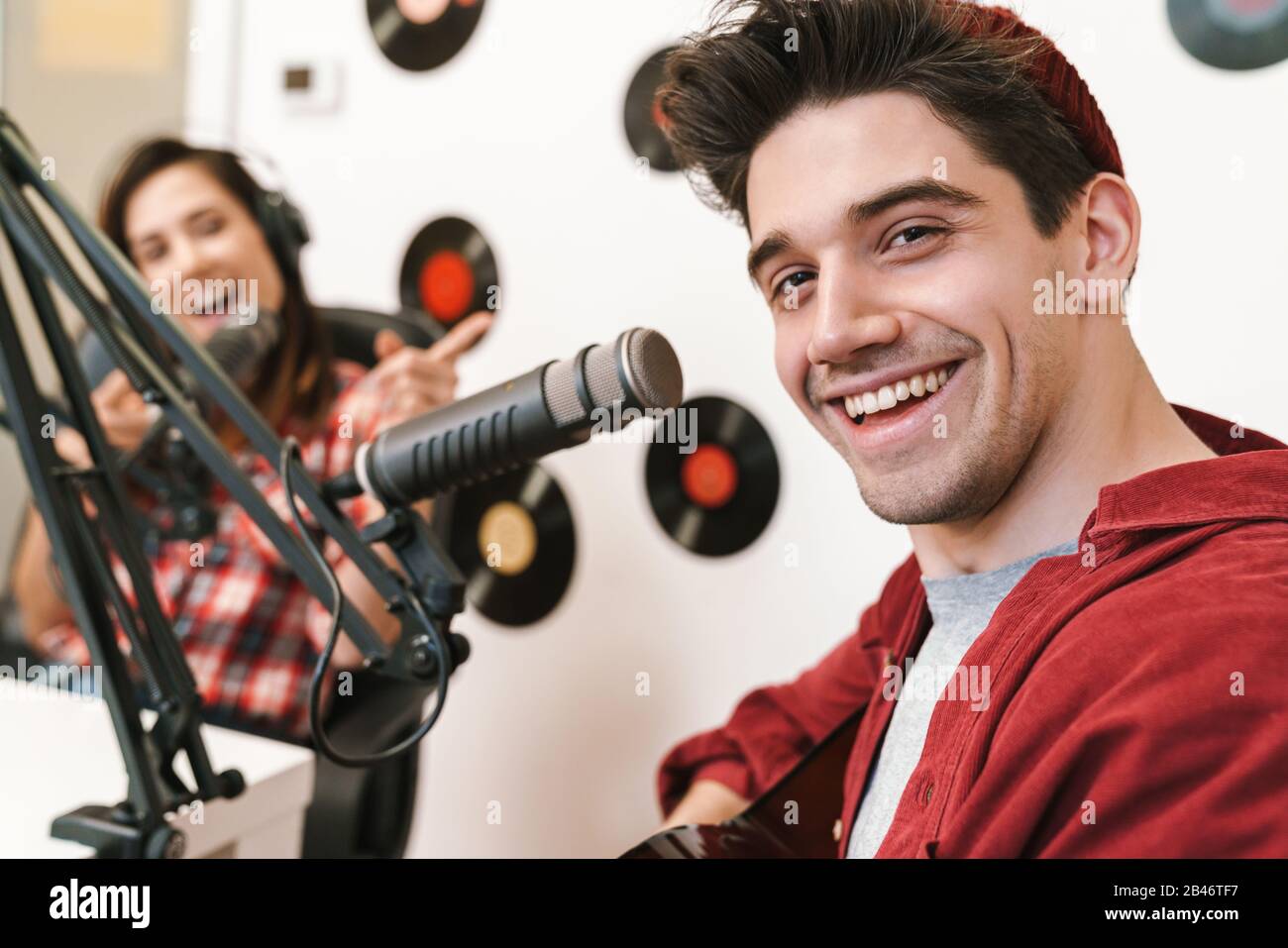 Bild von jungen fröhlichen kaukasischen Menschen, die bei Radiosendungen auftreten und Podcast-Aufnahmen für die Online-Show machen Stockfoto