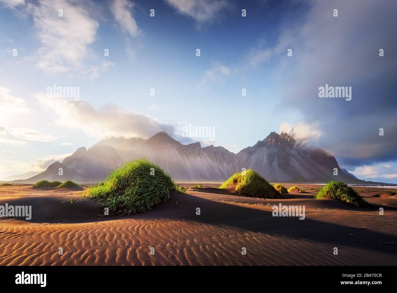 Wunderschöne Landschaft mit schwarzen Sanddünen und grasigen Buchten in der Nähe berühmter Stokksnes Berge am Vestrahorn cape, Island Stockfoto