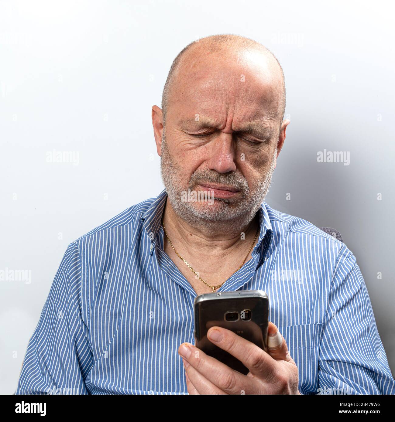 Ein Mann mittleren Alters langweilte sich beim Telefonieren Stockfoto