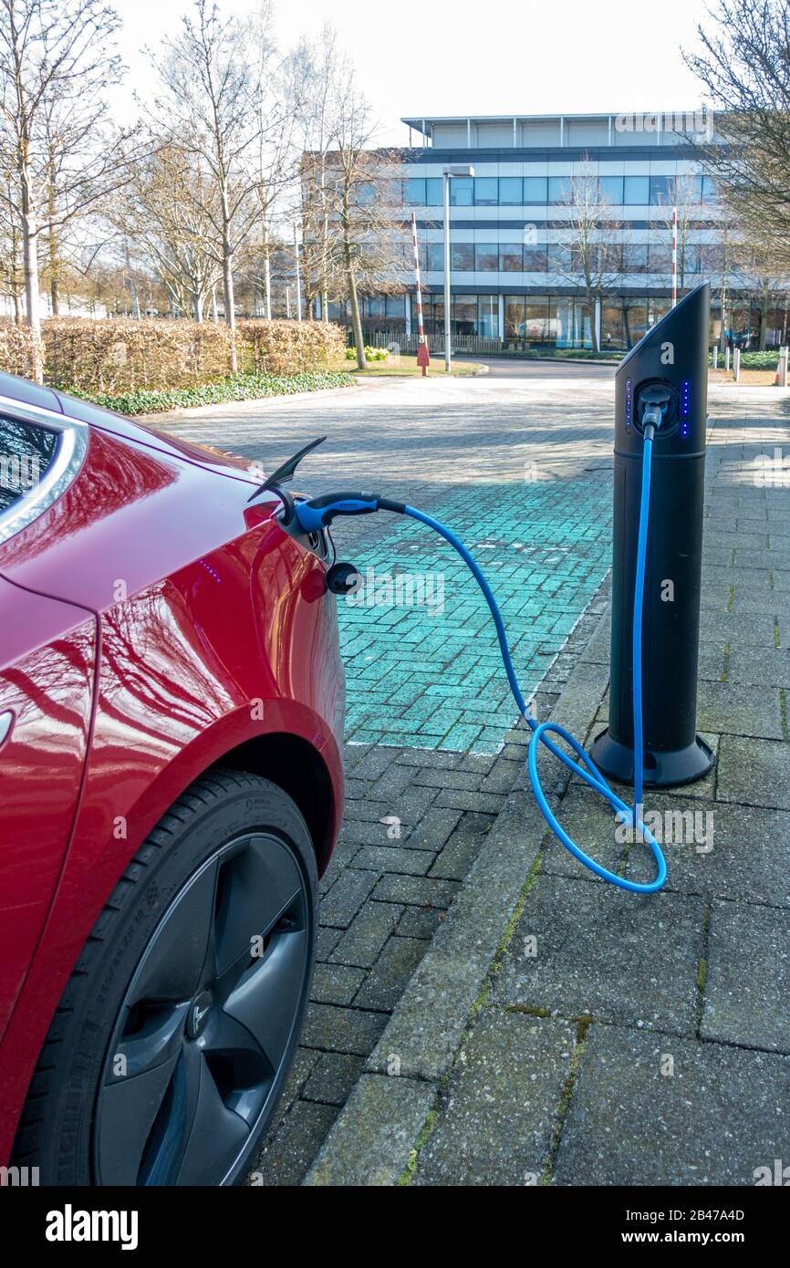 Ein Elektroauto, das an eine Ladestelle angeschlossen ist, um es aufzuladen. Stockfoto