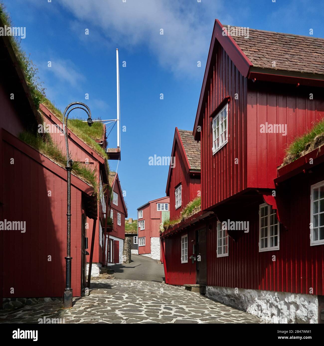 Dänemark, Halbinsel Tinganes, Torshavn, Streymoy, Färöer. Tinganes ist der historische Ort der färöischen landsstýri (Regierung) und ein zentraler Teil von Tórshavn. Der Name Tinganes bedeutet im färöischen "landtagspunkt" oder "landtagspunkt". Viele der Holzhäuser auf Tinganes wurden im 16. Und 17. Jahrhundert erbaut und haben die typische rote Farbe sowie das auf den Färöern sehr verbreitete Grasdach. Stockfoto