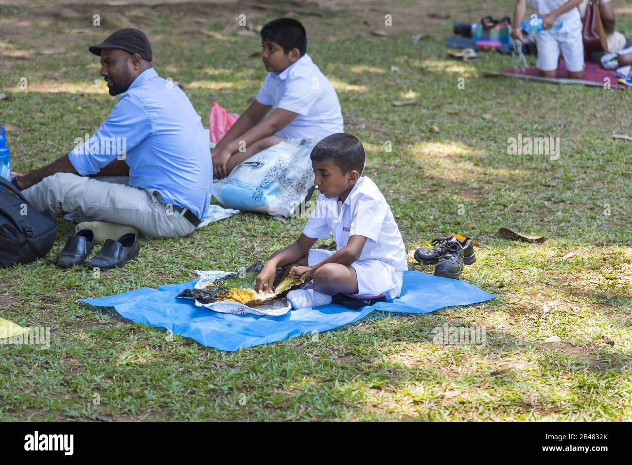 Kandy, Sri Lanka: 19.03.2019: Kleiner Schuljunge des Botanischen Gartens Peradeniya, der ein traditionelles Mittagessen mit Reis isst Stockfoto