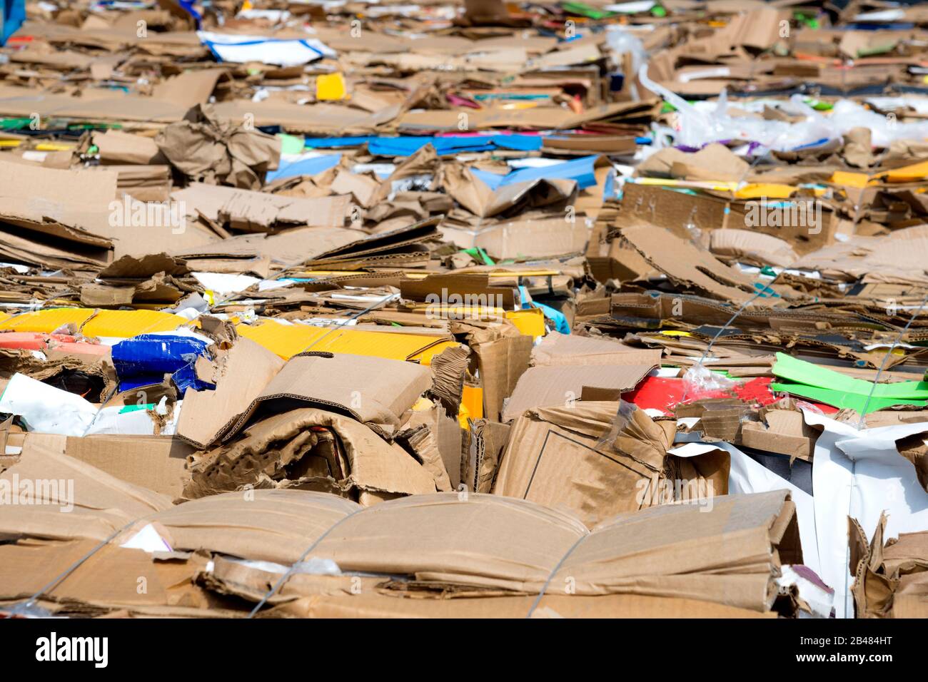 Kartonbündel, die recycelt werden sollen. Pappe wird in Ballen gebündelt. An einem sonnigen Tag ist draußen. Stockfoto