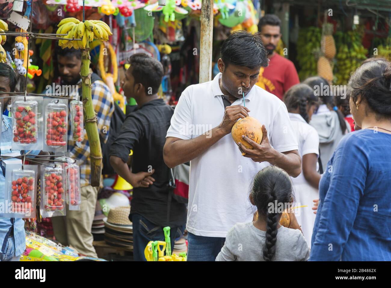 Nuwara Eliya, Sri Lanka: 20.03.2019: Traditionelles Obst- und Veg-Geschäft, Mann trinkt aus Kokosnuss. Stockfoto