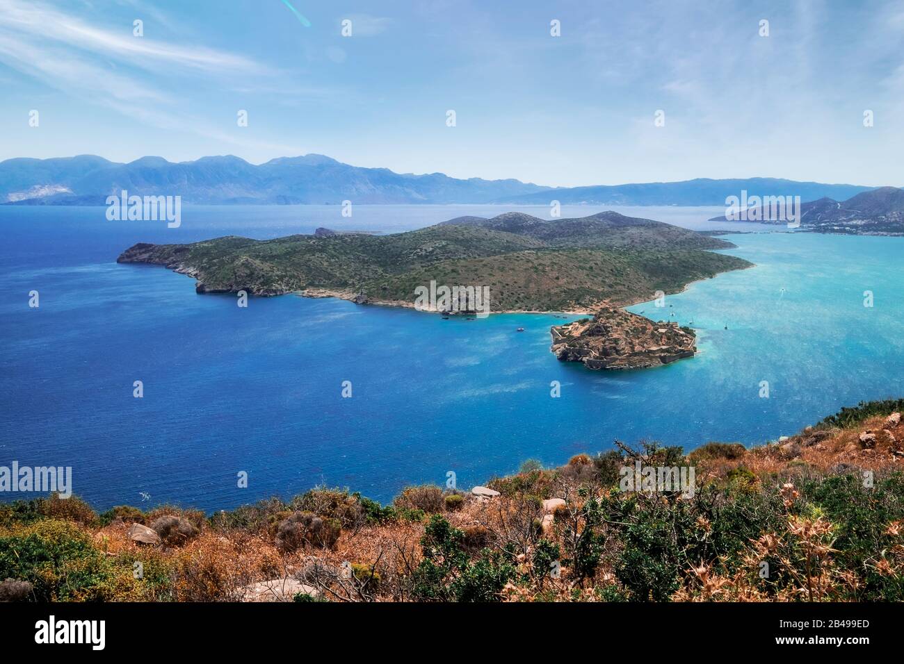 Erstaunliche Szene von Spinalonga Island mit alter Festung und ehemaliger Lepra-Kolonie. Boote, die türkisblaues Wasser der ägetischen See auf der Insel Crete schwimmen. Exotisch Stockfoto