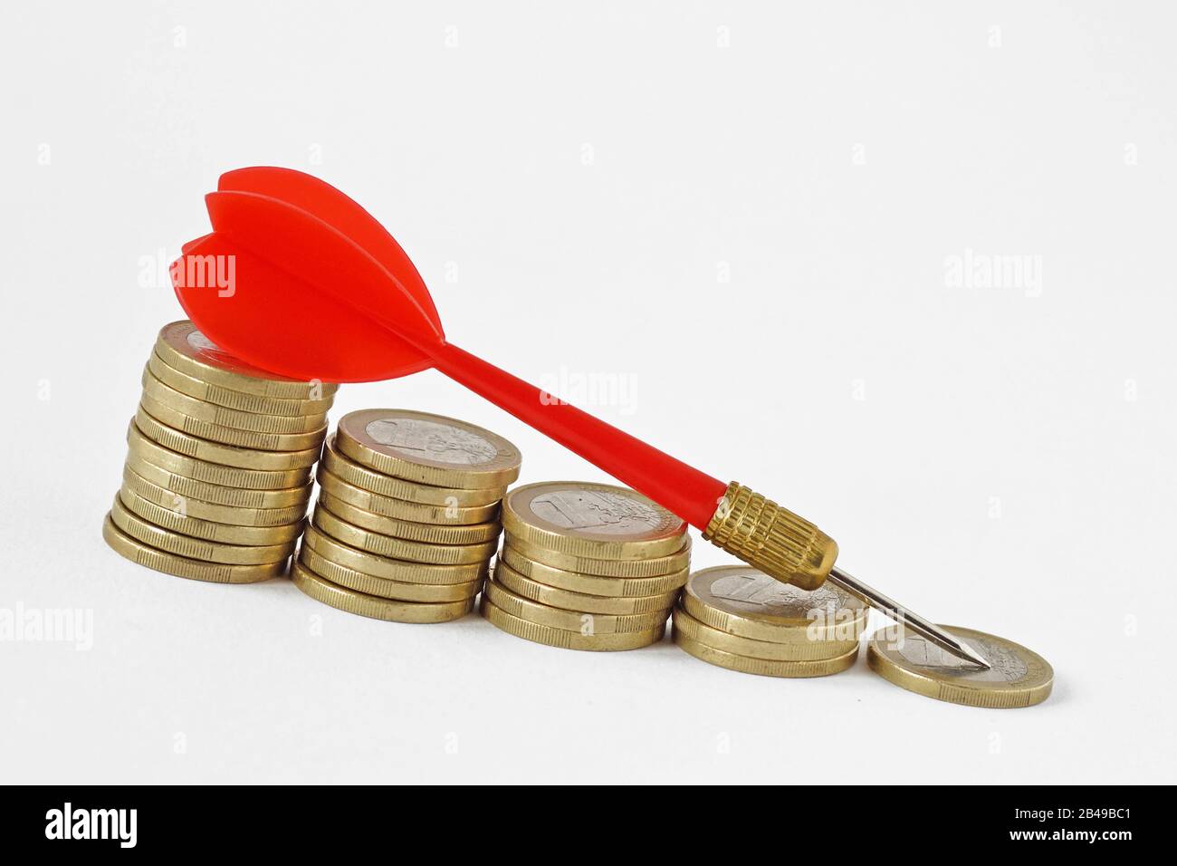 Roter Pfeil auf sinkenden gestapelten Münzen - Geldverlust Konzept Stockfoto