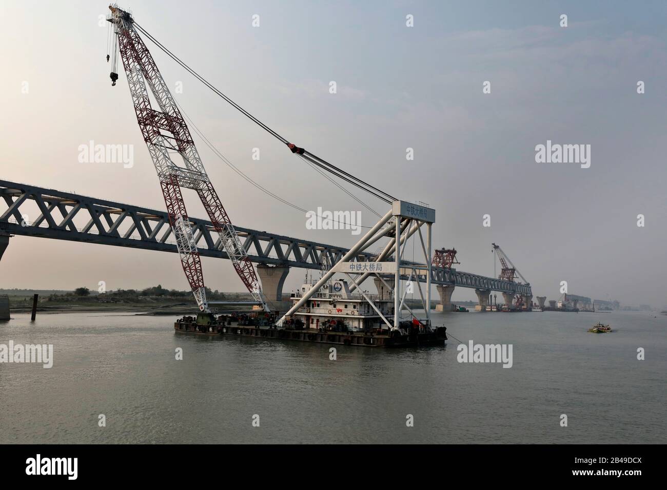 Munshiganj, Bangladesch - 04. März 2020: Die Bauarbeiten an der Padma-Mehrzweckbrücke laufen in vollem Gange am Ufer des Padma-Flusses. Fahrbahnrand und Stockfoto