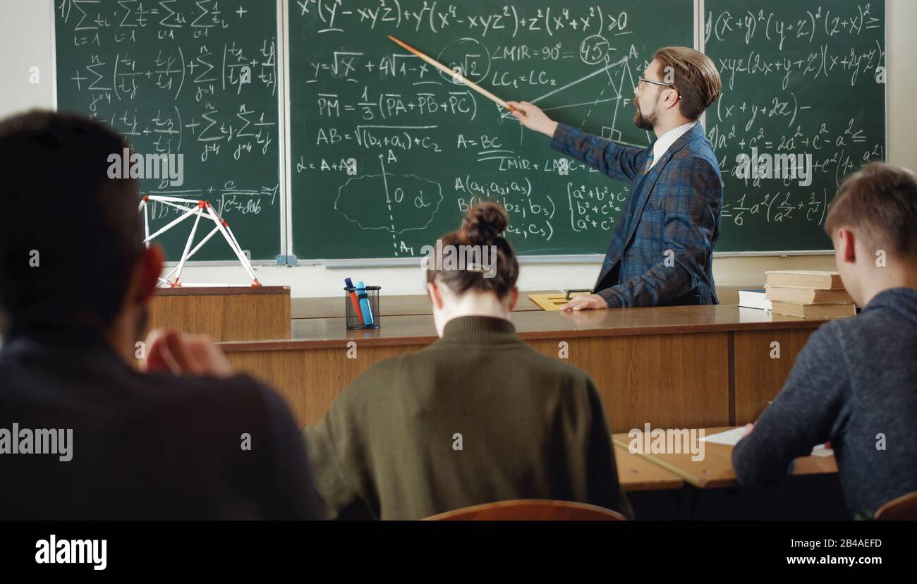 Mathematiklehrer, der auf das Schwarzen Brett zeigt Stockfoto