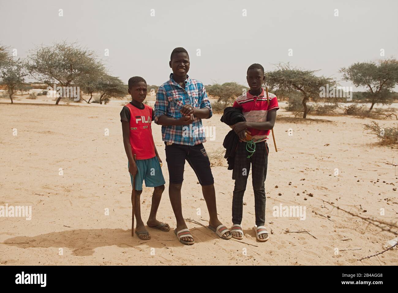 Soungou Roungou, Senegal, Afrika, 19. Januar 2020: Horizontale Fotografie von drei Jungen, die an einem sonnigen Tag im Freien stehen Stockfoto