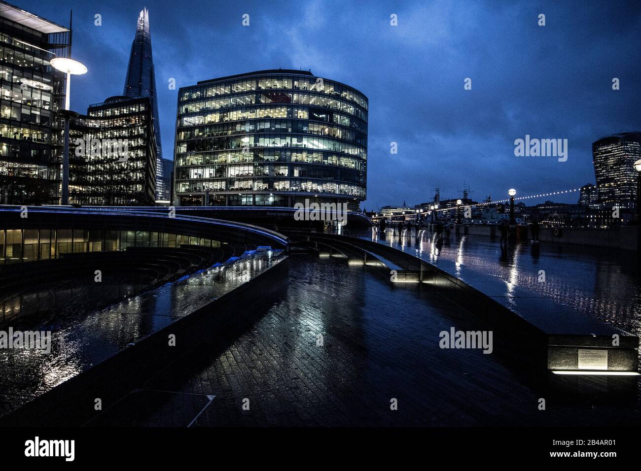 Moore London Riverside, Flussweg entlang des Rathausviertels der Southbank bei Dämmerung an einem nassen Winterabend, City of London, England, Großbritannien Stockfoto