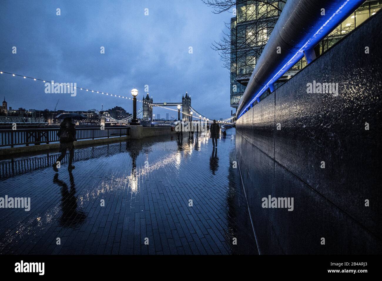 Moore London Riverside, Flussweg entlang des Rathausviertels der Southbank bei Dämmerung an einem nassen Winterabend, City of London, England, Großbritannien Stockfoto