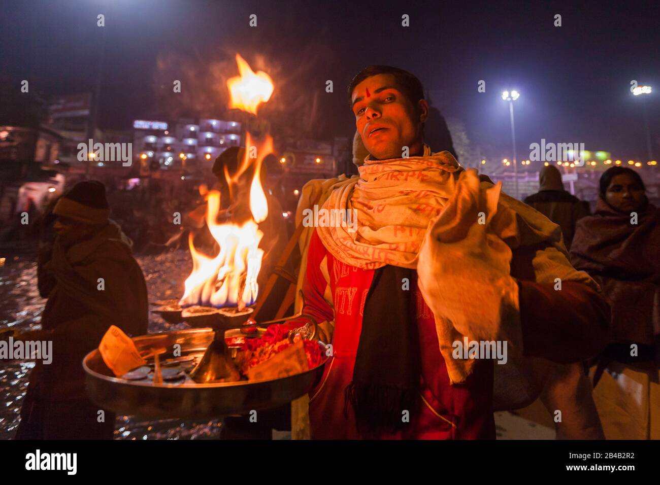 Indien, Uttarakhand, Haridwar, heilige Stadt des hinduismus, Kumbh Mela Hindu-Pilgerreise, Har Ki Pauri Ghat, heiliger Mann segnet Pilger nach aarti, Abendgebet Stockfoto