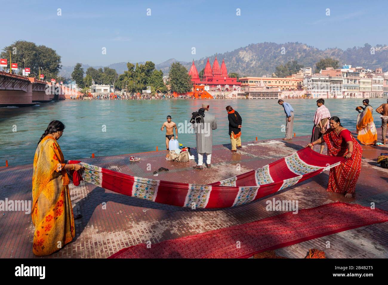Indien, Uttarakhand, Haridwar, heilige Stadt des hinduismus, Kumbh Mela Hindu-Pilgerreise, Frauen, die im Hintergrund einen Saree am Ganges- und Bholanath-Sevashram-Tempel trocknen Stockfoto