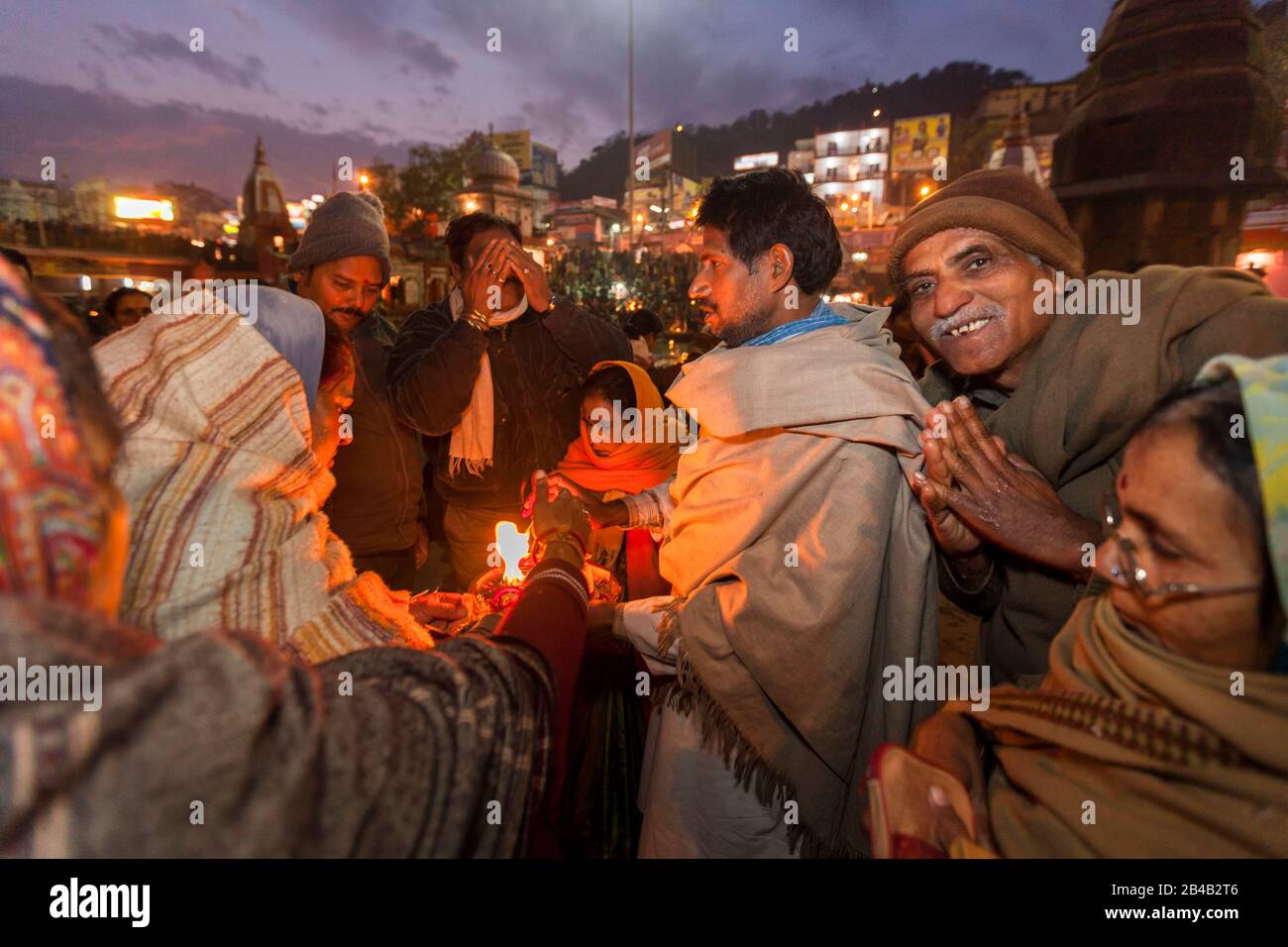 Indien, Uttarakhand, Haridwar, heilige Stadt des hinduismus, Kumbh Mela Hindu-Pilgerreise, Har Ki Pauri Ghat, heiliger Mann segnet Pilger nach aarti, Abendgebet Stockfoto