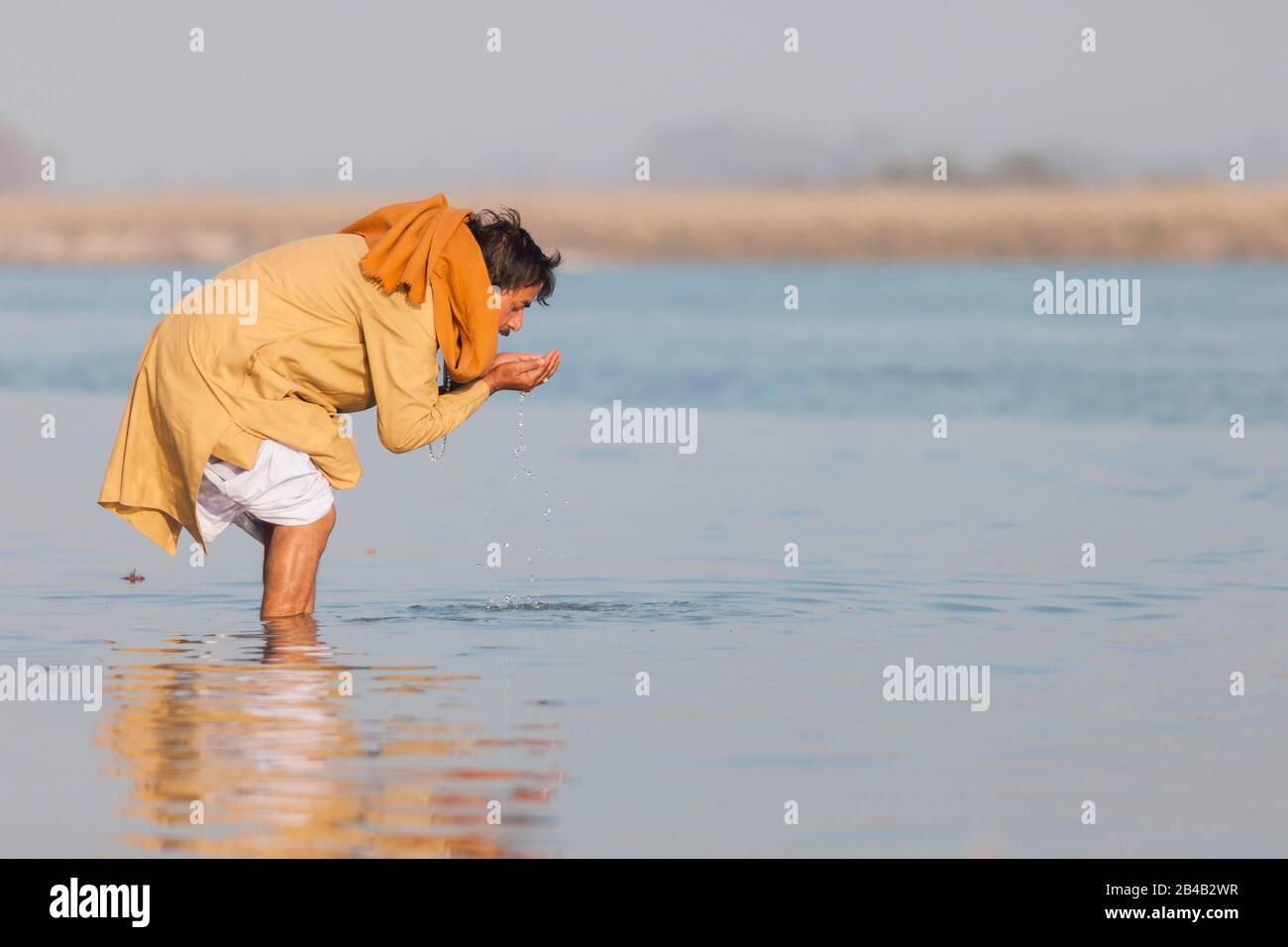 Indien, Uttarakhand, Haridwar, heilige Stadt des hinduismus, Kumbh Mela Hindu-Pilgerreise, Mann betend und Trinkwasser aus dem Fluss Ganges Stockfoto