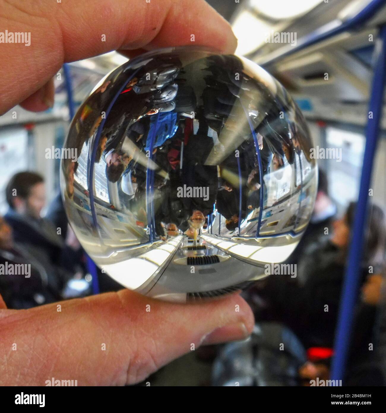 Ein von einem Pendler in der London Underground gehaltener Linsenkugel zeigt ein Bild auf dem Kopf innerhalb des Balls einer geschäftigen Kutsche. Von Gavin Crilly Photography, KEIN VERKAUF, KEIN SYNDICATION Kontakt für weitere Informationen Mob: 07810638169 Web: www.pressphotographergloucestershire.co.uk E-Mail: gavincrilly@gmail.com Das fotografische Urheberrecht (© 2015) wird von dem Ersteller der Werke zu jeder Zeit ausschließlich beibehalten und Verkäufe, Syndizierung oder das Angebot des Werks für eine zukünftige Veröffentlichung an Dritte ohne Wissen oder Zustimmung des Fotografen verstößt gegen das Copyright Designs and Patents Act 1988, (P Stockfoto