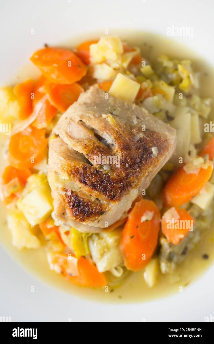 Ein Hühnerschenkel kaufte sich von einem Supermarkt, der auf einem George Foreman-Fettreduzierungsgrill gegrillt wurde, bevor er mit Karotten, Lauch, Zwiebeln gedünstet wurde Stockfoto