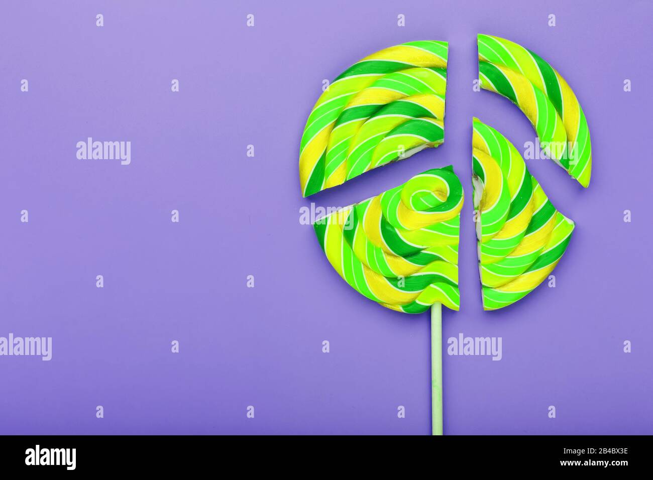 Lollipop ist in Stücke auf blauem Hintergrund aufgeteilt, Draufsicht mit Kopierbereich. Süßigkeiten-Konzept. Stockfoto