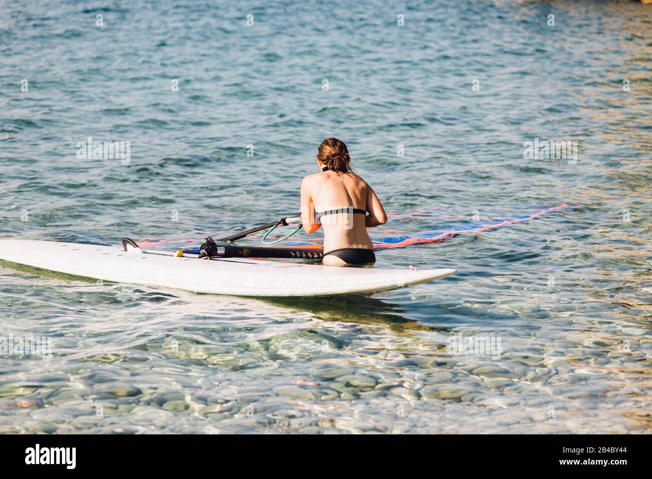 Junge Frau, die an der kroatischen Küste, Cres/Kroatien, surft Stockfoto