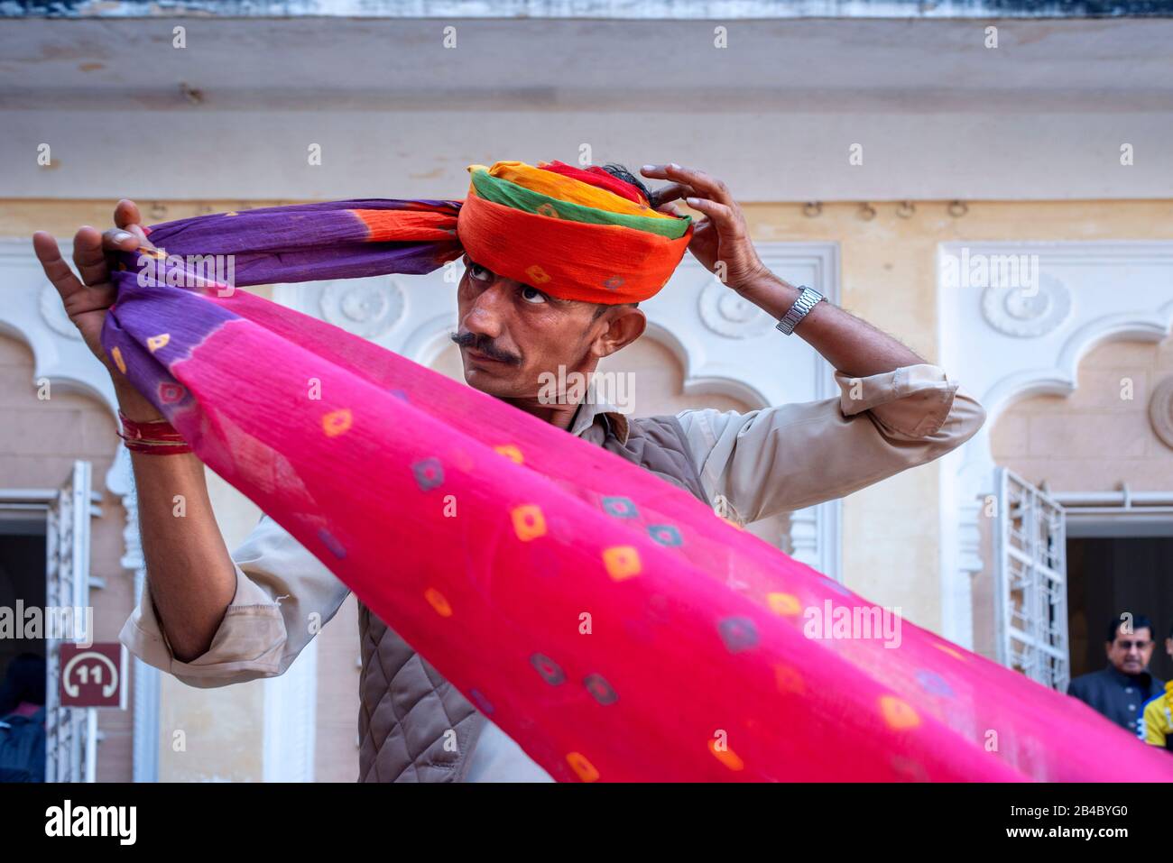 Hinduistische zeremonielle Wache, die Rajasthani-Turban im Mahrangarh Fort bei Jodhpur in Rajasthan, Nordindien, ansetzt. Dies ist eine der Exkursionen der Lu Stockfoto