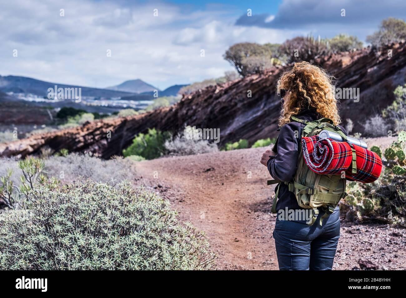 Trekkking-Frau im Freien mit Rucksack Natur und Berg genießen - alternatives Reise- und Urlaubskonzept - Erde und Schönheit genießen - Rückblick Stockfoto