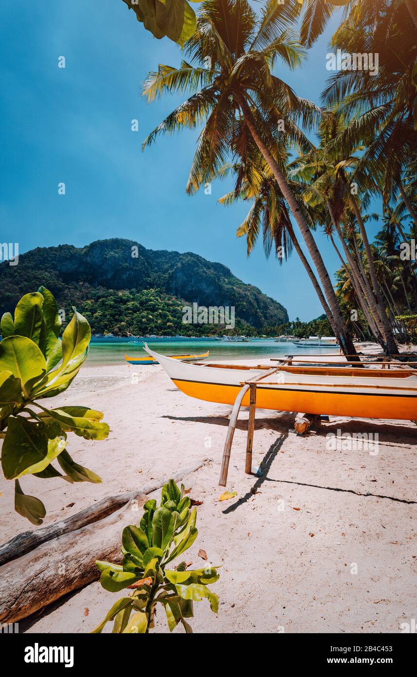 Banca Boote unter Palmen am Sandstrand in Corong corong, El Nido, Palawan, Philippinen. Stockfoto