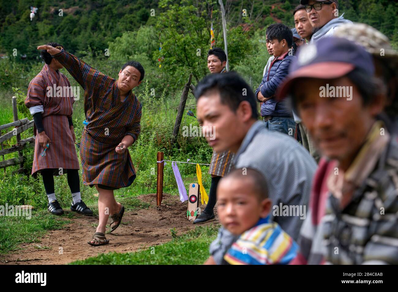 Männer spielen in Khuru wagt traditionelle bhutanische Sportart, in Paro Bhutan große Darts ins Freie zu werfen Stockfoto